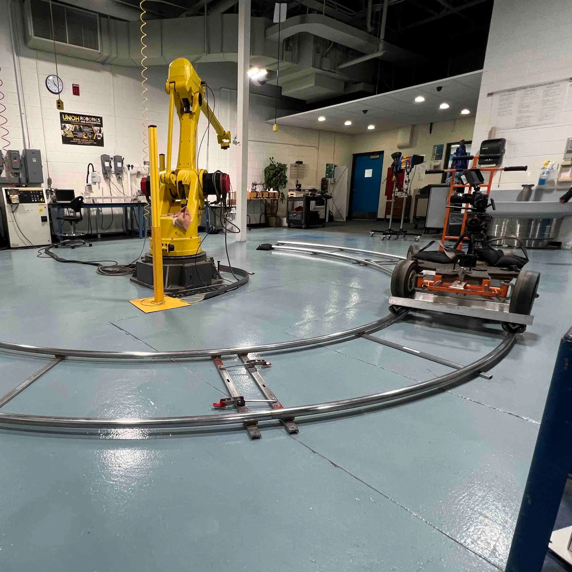 Camera dolly on curved track shooting an industrial robot arm